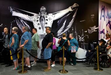 A classic Elvis Presley photo hangs above a line of opening-day visitors for Gracelands first-ever permanent exhibition outside of Memphis and in the Westgate Resorts on Thursday, April 23, 2015.