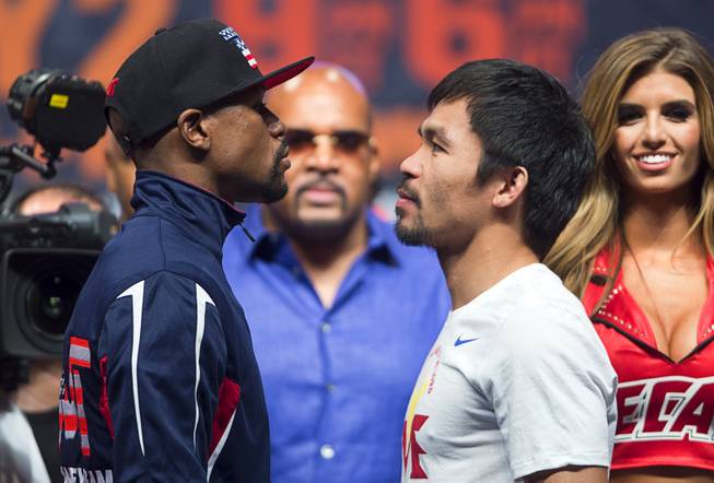 Undefeated WBC/WBA welterweight champion Floyd Mayweather Jr., left, and WBO welterweight champion Manny Pacquiao of the Philippines face off during an official weigh-in at the MGM Grand Garden Arena Friday, May 1, 2015. The boxers will fight in a welterweight unification bout at the arena on Saturday.