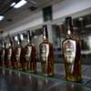 In this Thursday, March 26, 2015 photo, bottles of Santa Teresa "Gran Reserva" rum move along the assembly line at the factory in La Victoria, Aragua State, Venezuela. The local industry is benefiting from a larger rum renaissance, as the spirit ditches its association with drunken sailors and joins the ranks of liquors fussed over by connoisseurs. 
