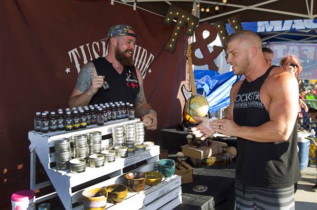 Dane Mentzer, left, the founder and CEO of Tusk & Hide Trading Co., talks with customer Elisha Quick at his booth in a vendor area of the Punk Rock Bowling & Music Festival in downtown Las Vegas Monday, May 25, 2015.