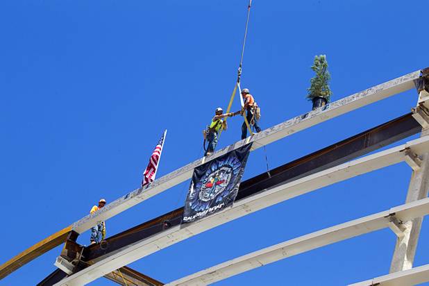Steelworkers Mike Dyke and Jason Luis shake hands on the final steel beam during a topping off ceremony for the Las Vegas Arena Wednesday, May 27, 2015. Representatives from MGM Resorts International and AEG, contractors Hunt-Penta and elected officials were on hand to celebrate the installation of the arena's final steel beam. The $375 million arena is scheduled to open in Spring 2016.