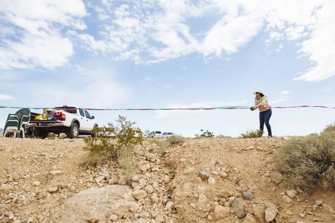 Yesenia Favela hangs streamers during artist Justin Favela's Family Fiesta at Michael Heizer's Double Negative located in the Moapa Valley on Mormon Mesa near Overton, Nevada on May 9, 2015.
