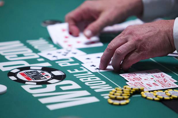 A dealer collects cards after a hand in the $565 buy-in "Colossus" event during the World Series of Poker at the Rio Monday, June 1, 2015.