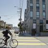 A man rides his bike past a new 40-unit Mission District condominium development Tuesday, June 2, 2015, in San Francisco. Finding a place to live has become so expensive and emotional that city supervisors are considering a 45-day moratorium on luxury housing in the Mission District.