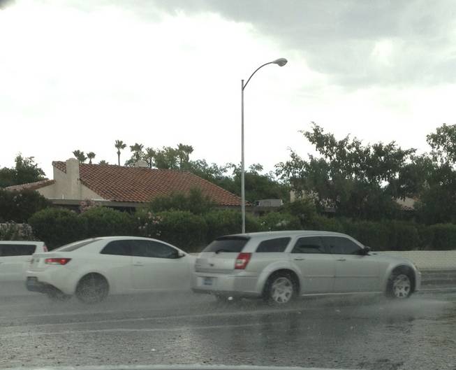 Motorists drive through puddles of rain on Eastern Avenue at Mohigan Way after a thunderstorm swept through the central Las Vegas Valley on Sunday, June 14, 2015.