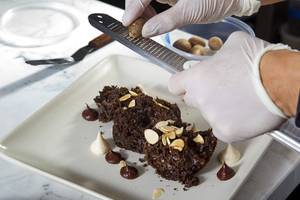 Executive pastry chef Carol Garcia grinds some fresh nutmeg onto an Aztec Cake at the Hexx chocolate room in Paris Las Vegas Tuesday, June 16, 2015.