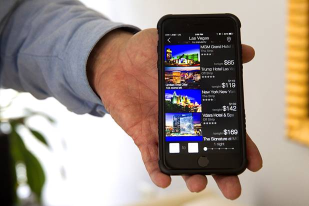 Jim Ferguson, co-founder of Roomlia, displays his iPhone with the Roomlia app in the company's offices Thursday, June 25, 2015. Roomlia is a mobile hotel booking app for iPhone and Android devices.