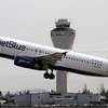 In this April 23, 2013, file photo, a JetBlue plane takes off in view of the air traffic control tower at Seattle-Tacoma International Airport in Seattle.
