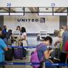 Travelers line up at a United Airlines check-in counter at Hartsfield–Jackson Atlanta International Airport Wednesday, July 8, 2015, in Atlanta. All United Continental flights in the U.S. were grounded Wednesday due to computer problems. Just shy of two hours after the problems began, the Federal Aviation Administration lifted the ground stop order.