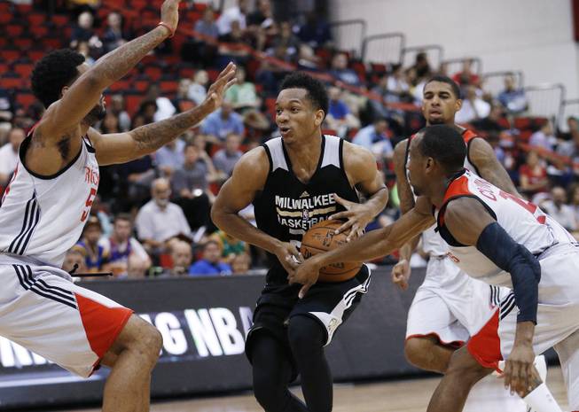 Milwaukee Bucks’ Rashad Vaughn drives between Houston Rockets’ DJ Kennedy, left, and Will Cummings, right, during the second half of an NBA summer league basketball game Wednesday, July 15, 2015, at the Cox Pavilion.