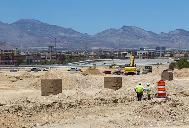 Workers look at plans at a residential development near Patrick Lane and Riley Street Tuesday, July 28, 2015.