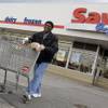 In this April 12, 2011, photo, shopper Andrew Boston leaves the Save-A-Lot grocery store with his purchases in Northfield, Ohio. 