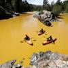 In this Thursday, Aug. 6, 2015, photo, people kayak in the Animas River near Durango, Colo., in water colored yellow from a mine waste spill. A crew supervised by the U.S. Environmental Protection Agency has been blamed for causing the spill while attempting to clean up the area near the abandoned Gold King Mine.