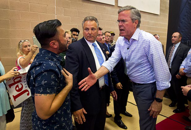 Republican presidential candidate former Florida Gov. Jeb Bush, right, shakes hands with activist A.J. Buhay at the end of a town hall meeting at the Pearson Community Center in North Las Vegas Wednesday, Aug. 12, 2015. Activists disrupted the end of the meeting with chants of "Black lives matter."