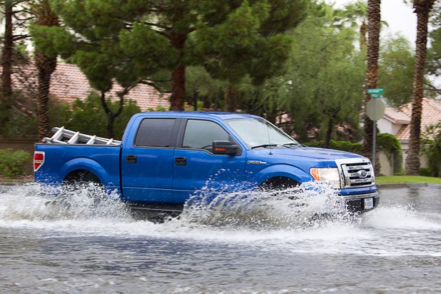 A truck drives through flood waters on Wigwam Parkway during a thunderstorm in Henderson, Aug. 13, 2015.