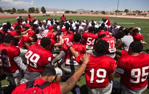 UNLV players, coaches and staff take a moment for prayer following a scrimmage at Nellis AFB on Saturday, August 15, 2015.