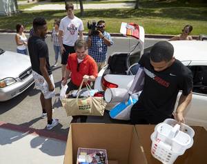 UNLV President Len Jessup and members of the UNLV men's basketball team help unload cars during freshman dorm move-in day at Dayton Hall on Wednesday, Aug. 19, 2015. 