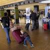 In this March 24, 2015, photo, Colin Drummond, 4, pushes luggage from behind as he walks with family members to check in a relative for an Alaska Airlines flight at Seattle-Tacoma International Airport. Fliers in certain markets are seeing bargain flights as fare wars make a limited return. 