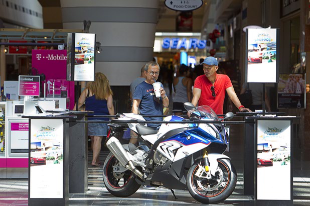 Men look over a motorcycle, one of the prizes in a timeshare sweepstakes, at the Boulevard Mall Sunday, Sept. 6, 2015.