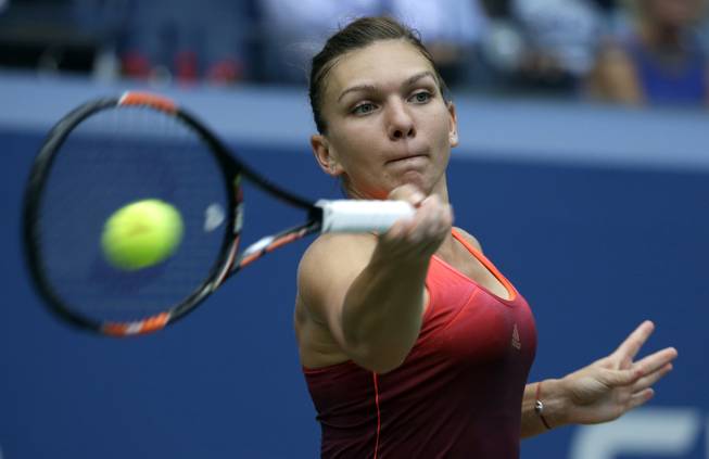 Simona Halep, of Romania, returns a shot to Victoria Azarenka, ...