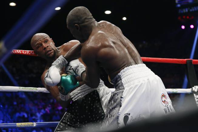 Andre Berto, right, punches Floyd Mayweather Jr. during their welterweight title fight Saturday. Mayweather, who won the fight, ran his record to 49-0, tying a mark set by the late heavyweight champion Rocky Marciano.