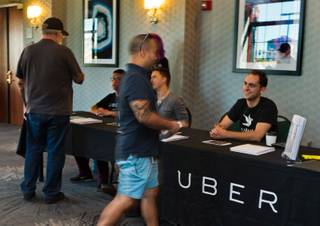 Uber workers welcome and instruct applicants on their next steps through the process at the Uber Activation Center at Hampton Inn Tropicana on Wednesday, September 16, 2015.