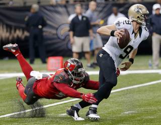 New Orleans Saints quarterback Drew Brees, right, scrambles under pressure from Tampa Bay Buccaneers defensive end George Johnson in the first half of an NFL football game in New Orleans on Sunday, Sept. 20, 2015.