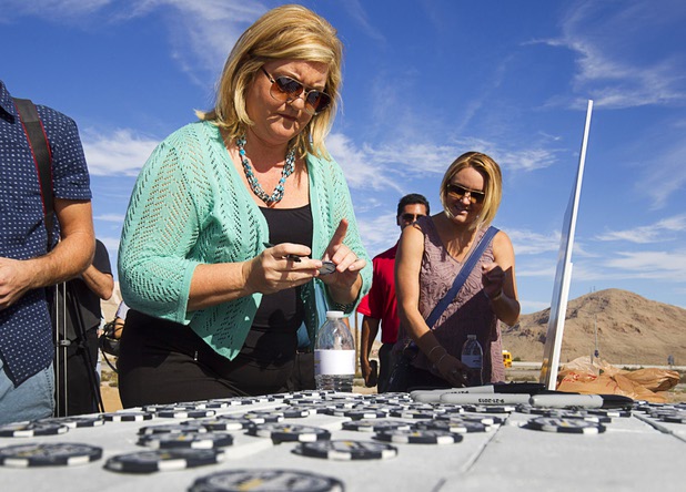 Rebekah Johnson, a senior account executive with Hello! Las Vegas, signs a commemorative chip during a ground breaking ceremony for Speed Vegas, a $30 million, 90-acre racetrack project on Las Vegas Boulevard south of the M Resort, Monday, Sept. 21, 2015. The chips will be displayed on a wall at the track's Welcome Center. The project is expected to open in early 2016.