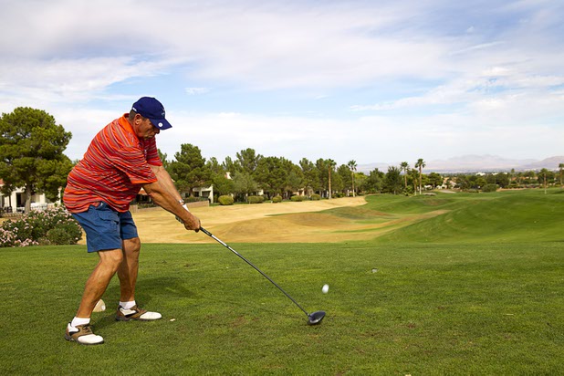 Larry White of Puyallup, Wash. drives off the eighth tee at the Palm Valley Golf Course in Summerlin Monday Sept. 28, 2015. The area of dead grass at left (in yellow) will be converted into desert landscaping to save water.