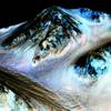 This undated photo provided by NASA and taken by an instrument aboard the agency's Mars Reconnaissance Orbiter shows dark, narrow, 100 meter-long streaks on the surface of Mars that scientists believe were caused by flowing streams of salty water. Researchers said Monday, Sept. 28, 2015, that the latest observations strongly support the longtime theory that salt water in liquid form flows down certain Martian slopes each summer.