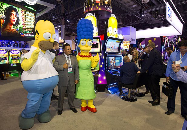Homer and Marge Simpson pose with attendees near a bank of Simpsons slot machines at the Scientific Games booth during the Global Gaming Expo (G2E) at the Sands Expo Center Tuesday, Sept. 29, 2015.