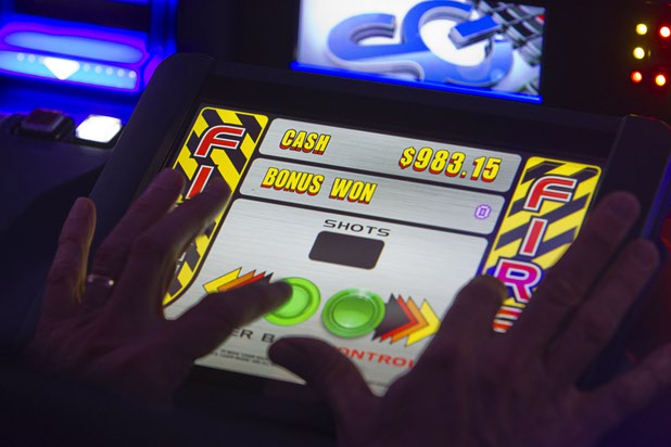 A player tries out the skill-based bonus round of the Space Invaders slot machine by Scientific Games during the Global Gaming Expo (G2E) at the Sands Expo Center Tuesday, Sept. 29, 2015.