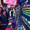 People try out the Space Invaders slot machine by Scientific Games during the Global Gaming Expo (G2E) at the Sands Expo Center Tuesday, Sept. 29, 2015. The slots include a skill-based bonus round.