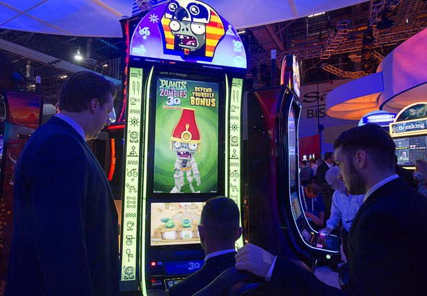People look over a Plants vs. Zombies 3D slot machine at the IGT booth during the Global Gaming Expo (G2E) at the Sands Expo Center Tuesday, Sept. 29, 2015.
