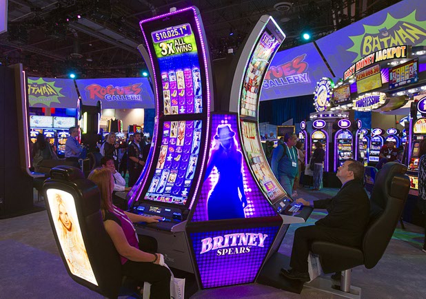 People try out Britney Spears-themed slot machines in the Aristocrat booth during the Global Gaming Expo (G2E) at the Sands Expo Center Tuesday, Sept. 29, 2015.