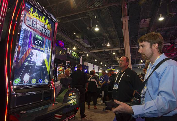 Brian Perego plays a skill-based Guitar Warrior slot game at the Next Gaming booth during the Global Gaming Expo (G2E) at the Sands Expo Center Tuesday, Sept. 29, 2015. The machine plays a predetermined wager every time you hit the correct note.