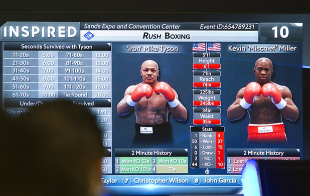 Attendees look over the Rush Boxing game featuring  former heavyweight boxing champion Mike Tyson at the Inspired booth during the second day of the Global Gaming Expo (G2E) in the Sands Expo Center Wednesday, Sept. 30, 2015.