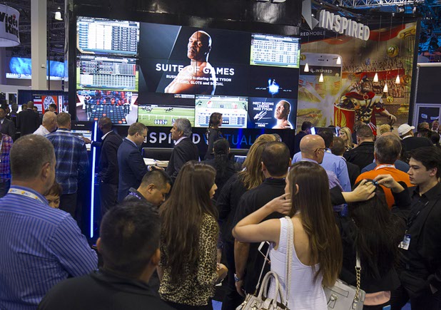 Attendees line up to get their photo taken with former heavyweight boxing champion Mike Tyson at the Inspired booth during the second day of the Global Gaming Expo (G2E) in the Sands Expo Center Wednesday, Sept. 30, 2015. Tyson was promoting Inspired's Rush Boxing game, which features the former champion.