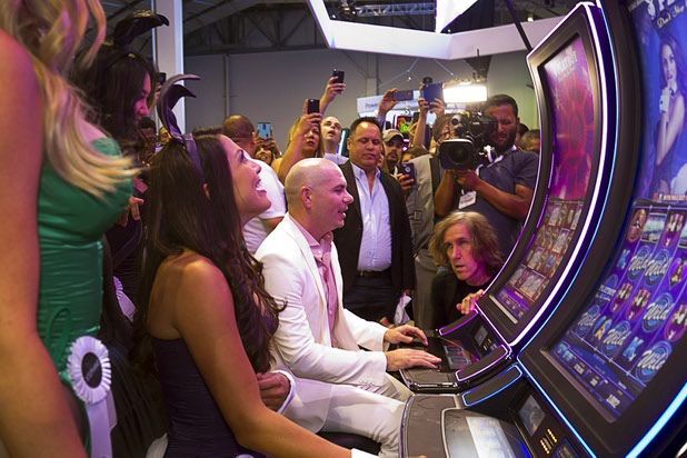 Pitbull tries out a Playboy slot machine at the Scientific Games booth during the second day of the Global Gaming Expo (G2E) in the Sands Expo Center Wednesday, Sept. 30, 2015. The slots feature Playboy Playmates and Pitbull.