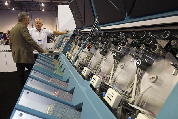 A currency counting machine by Giesecke & Devrient is displayed during the second day of the Global Gaming Expo (G2E) in the Sands Expo Center Wednesday, Sept. 30, 2015. The machine can sort and counts 22 bank notes per second, a representative said.