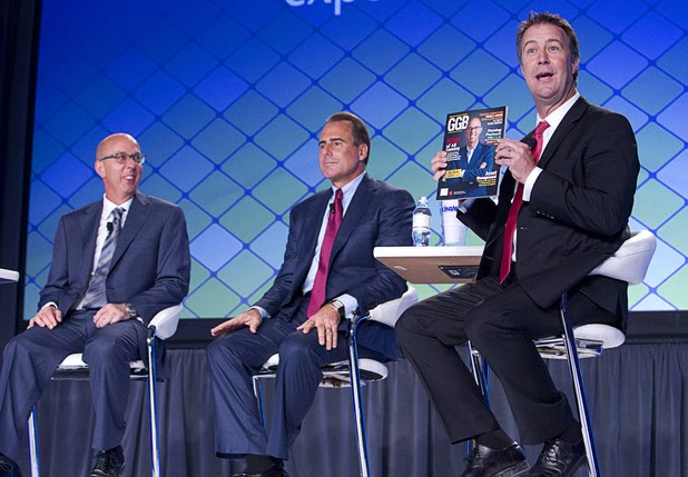 Bo Bernhard, right, executive director of the International Gaming Institute at UNLV, holds up a magazine featuring Gavin Isaacs, left, CEO of Scientific Games, during a CEO round table at the Global Gaming Expo (G2E) in the Sands Expo Center Wednesday, Sept. 30, 2015.  Mark Frissora, CEO/president of Caesars Entertainment, sits at center.