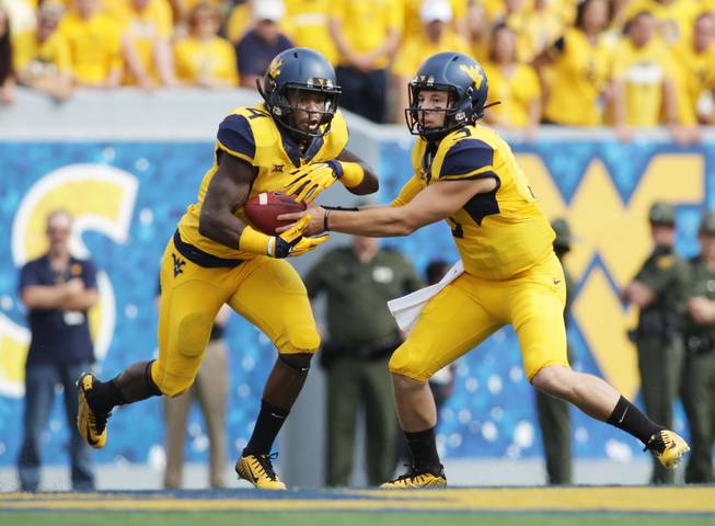 West Virginia running back Wendell Smallwood (4) West Virginia quarterback Skyler Howard (3) during the first half/ second half of a NCAA college football game, Saturday, Sept. 26, 2015, in Morgantown, W.Va.
