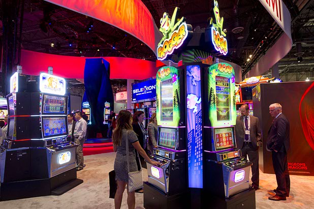 People look over a Frogger slot machine in the Konami booth during the Global Gaming Expo (G2E) in the Sands Expo Center Thursday Oct. 1, 2015.