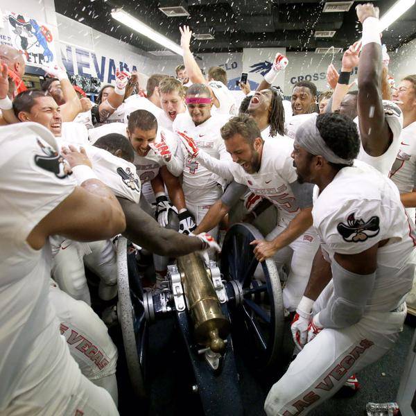 UNLV football players celebrate with the Fremont Cannon after defeating UNR 23-17 on Saturday, Oct. 3, 2015, in Reno.