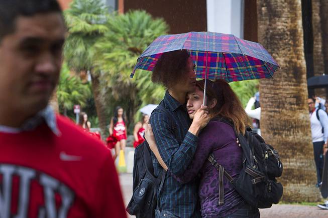 UNLV students Joshua Clark and Parisa Soleimani share an umbrella during a light rain at UNLV Monday, Oct. 5, 2015.