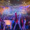 In this May 11, 2014, photo, fans watch the opening ceremony of the "League of Legends" season four World Championship Final between South Korea and China's Royal Club in Paris. Around the world, fans gather en masse to watch video game players compete in high-stakes tournaments. Fans also bet on the outcomes.