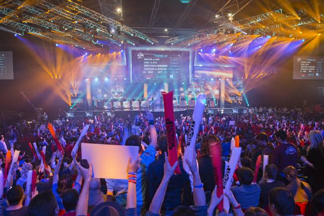 In this May 11, 2014, photo, fans watch the opening ceremony of the "League of Legends" season four World Championship Final between South Korea and China's Royal Club in Paris. Around the world, fans gather en masse to watch video game players compete in high-stakes tournaments. Fans also bet on the outcomes.