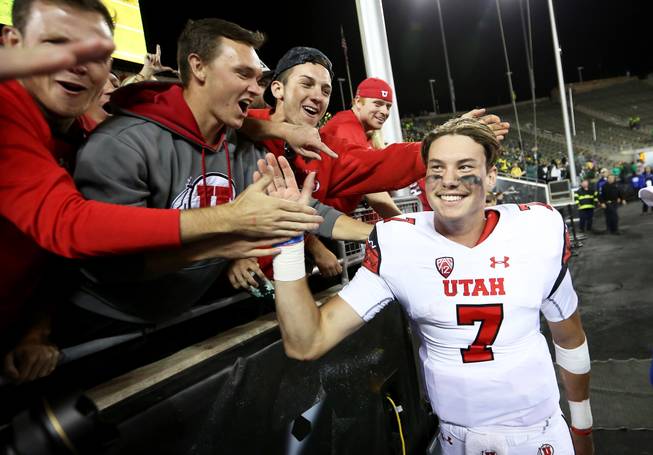 Utah quarterback Travis Wilson (7) high-fives the crowd after an NCAA college football game against Oregon, Saturday, Sept. 26, 2015, in Eugene, Ore. Utah won 62-20.