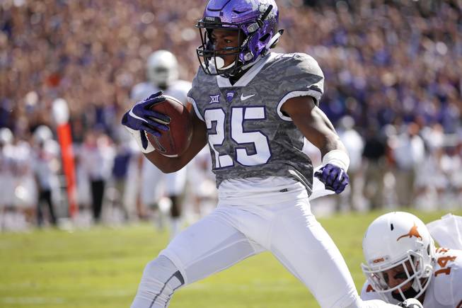 TCU wide receiver KaVontae Turpin (25) takes a touchdown pass across the goal line to score as Texas safety Dylan Haines (14) pursues in the first quarter of an NCAA football game Saturday, Oct. 3, 2015, in Fort Worth, Texas.