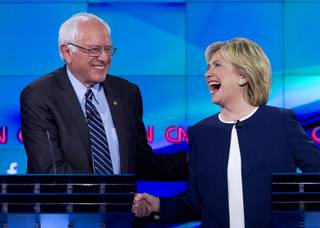Vermont Senator Bernie Sanders, left, gets an appreciative handshake from former Secretary of State Hillary Rodham Clinton during the CNN Democratic Presidential Debate at the Wynn Las Vegas Tuesday, Oct. 13, 2015. Clinton offered her hand to Sanders after he said 